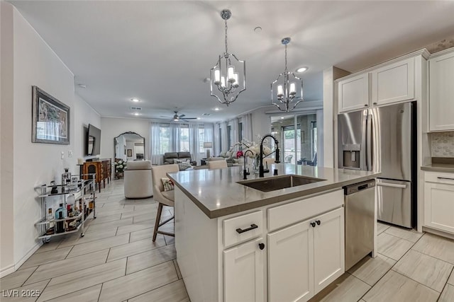 kitchen featuring white cabinetry, a center island with sink, ceiling fan, and sink