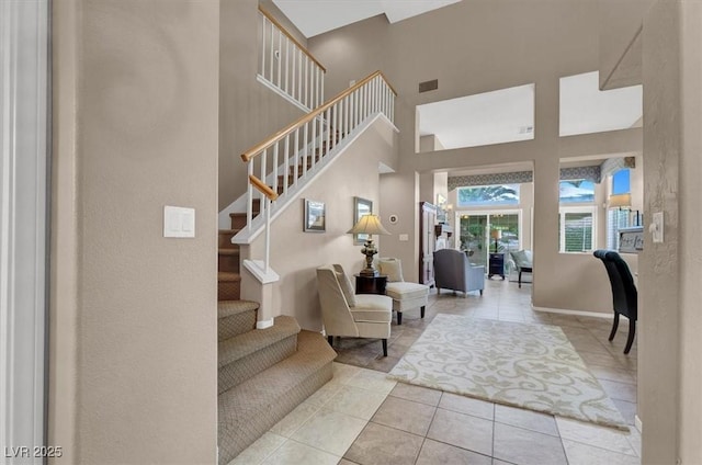 interior space featuring a high ceiling and light tile patterned flooring