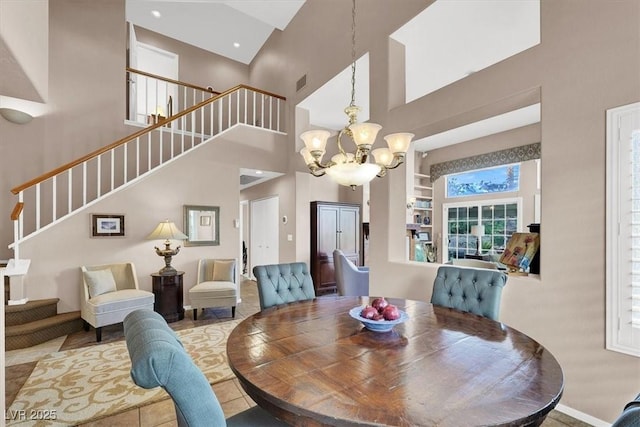 dining area with a high ceiling, a notable chandelier, and built in shelves