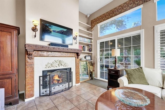 living area with a tile fireplace, light tile patterned flooring, and built in features