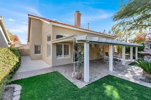 back of property featuring a patio area and a pergola