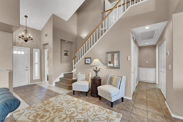 tiled foyer featuring a towering ceiling and a notable chandelier