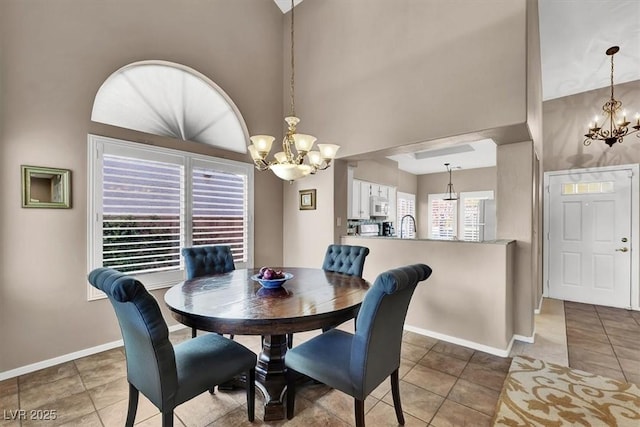 tiled dining space featuring a towering ceiling and a chandelier