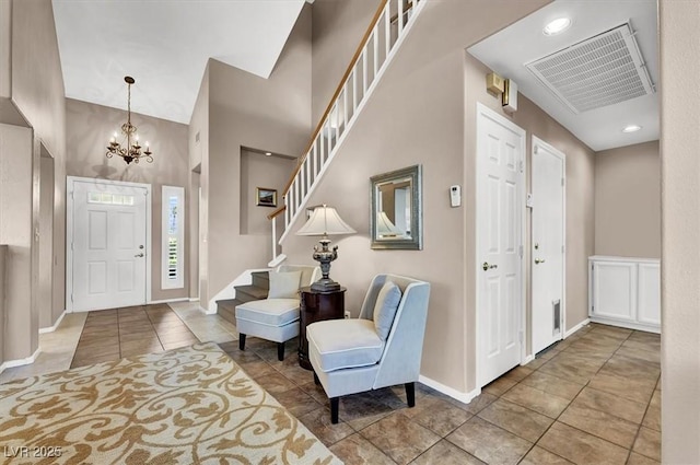 tiled foyer with a chandelier