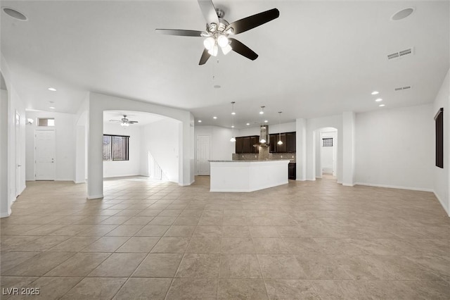 unfurnished living room with ceiling fan and light tile patterned floors