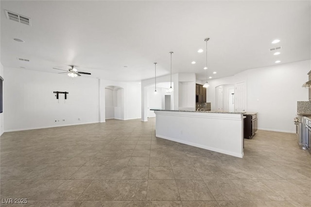 kitchen featuring backsplash, hanging light fixtures, light stone countertops, ceiling fan, and light tile patterned flooring