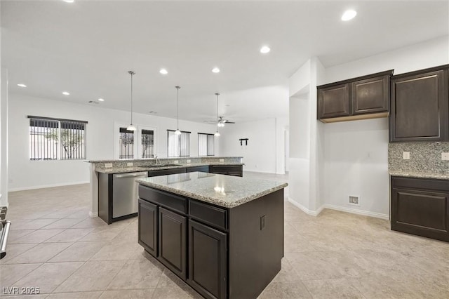 kitchen with sink, ceiling fan, stainless steel dishwasher, hanging light fixtures, and a kitchen island