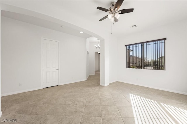 tiled empty room with ceiling fan with notable chandelier