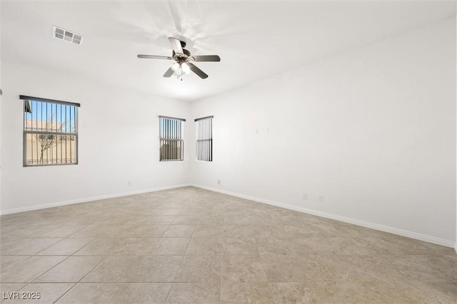 tiled spare room featuring ceiling fan