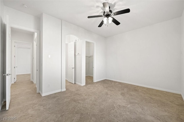 unfurnished bedroom with a walk in closet, ceiling fan, and a closet