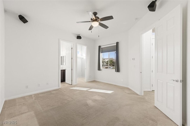 unfurnished bedroom featuring connected bathroom, ceiling fan, and light colored carpet