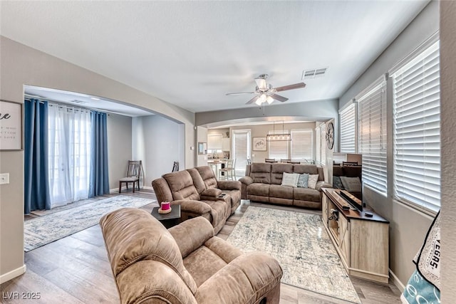 living room featuring ceiling fan and light hardwood / wood-style flooring