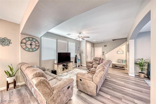 living room with ceiling fan and light hardwood / wood-style flooring