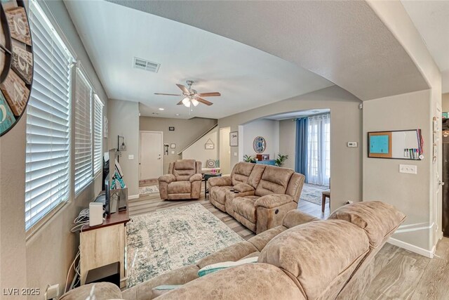 living room with ceiling fan and light hardwood / wood-style flooring