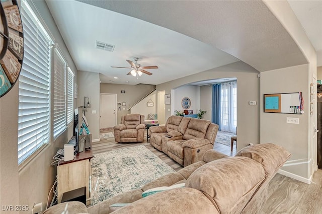 living room with light hardwood / wood-style floors and ceiling fan