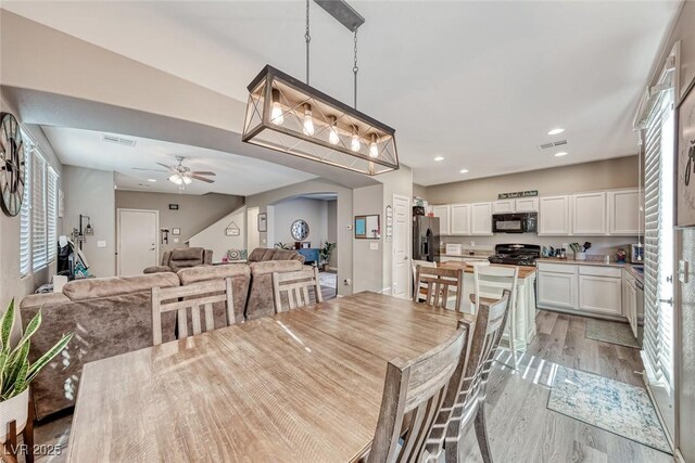 dining area with ceiling fan and light hardwood / wood-style flooring