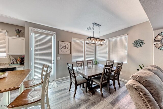 dining area featuring light hardwood / wood-style flooring and a chandelier