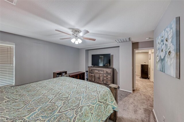 bedroom with a textured ceiling, ceiling fan, and light colored carpet