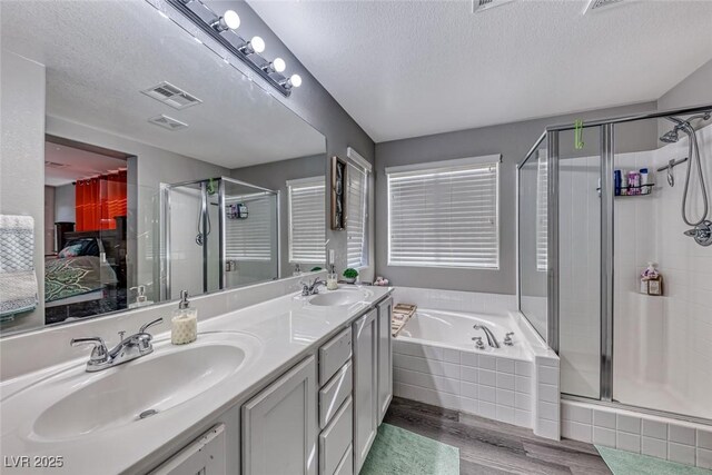 bathroom featuring hardwood / wood-style flooring, a textured ceiling, separate shower and tub, and vanity