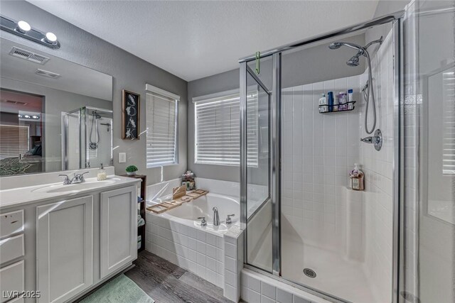 bathroom featuring a textured ceiling, vanity, independent shower and bath, and hardwood / wood-style floors