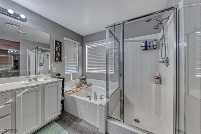 bathroom featuring hardwood / wood-style flooring, vanity, and plus walk in shower