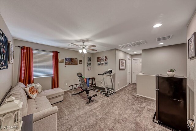 exercise area featuring ceiling fan and light colored carpet