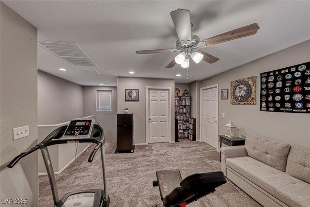 exercise room with ceiling fan and light colored carpet