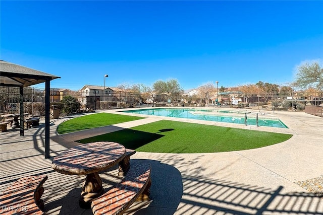 view of pool with a patio and a yard