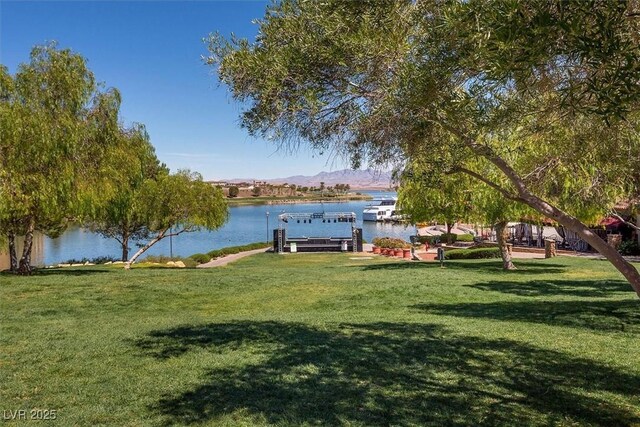 view of dock with a yard and a water and mountain view