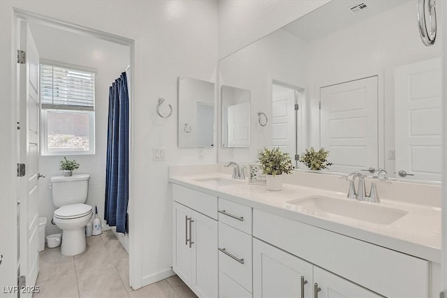 bathroom featuring vanity, tile patterned floors, and toilet