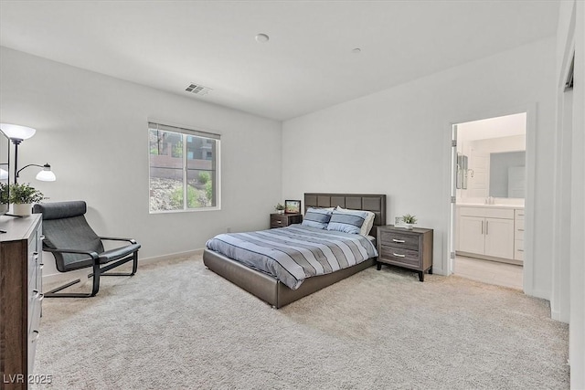 bedroom featuring light colored carpet and ensuite bathroom