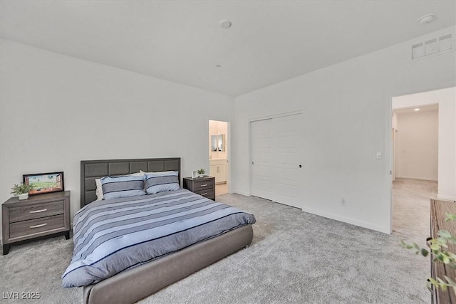 bedroom with light colored carpet and connected bathroom