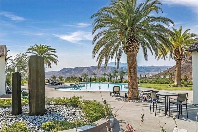 view of pool with a patio and a mountain view