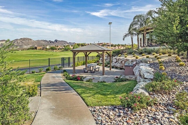 view of property's community featuring a gazebo, a lawn, and a mountain view