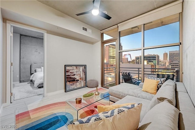 living room with ceiling fan, light hardwood / wood-style flooring, and floor to ceiling windows