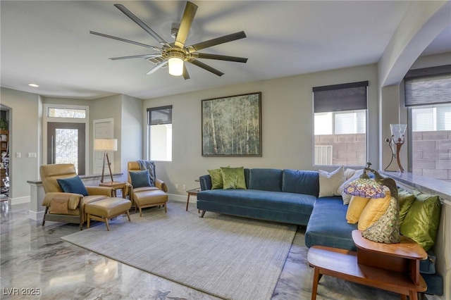 living room with concrete flooring and ceiling fan