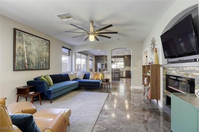 living room featuring ceiling fan and a fireplace