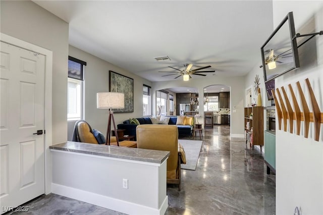 living room with ceiling fan and plenty of natural light