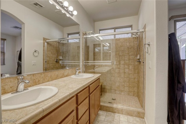 bathroom featuring a shower with door, vanity, and tile patterned floors