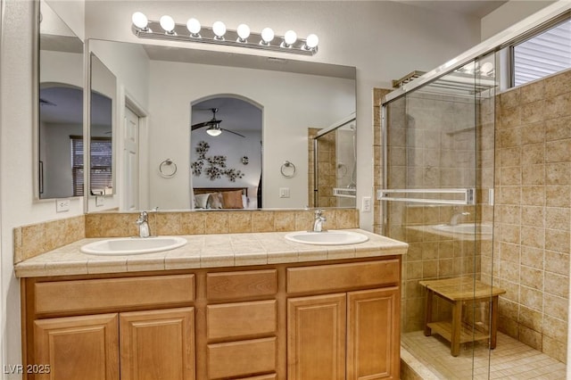 bathroom with ceiling fan, walk in shower, and vanity