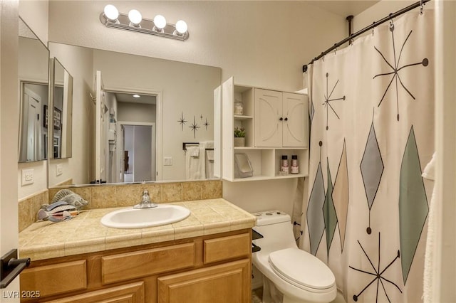 bathroom featuring toilet, a shower with shower curtain, and vanity