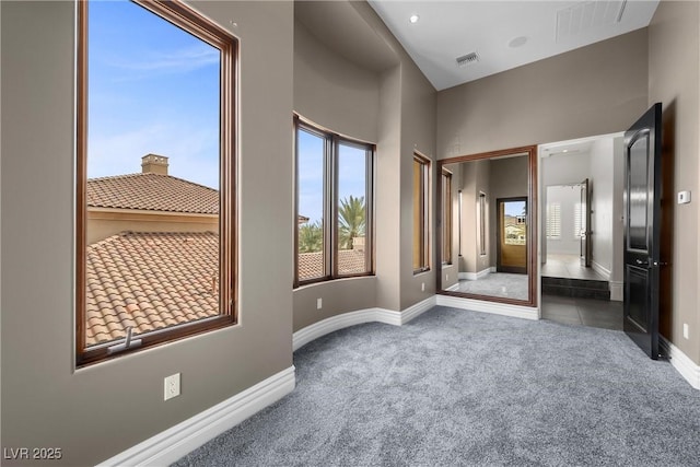 interior space featuring baseboards, visible vents, and carpet flooring