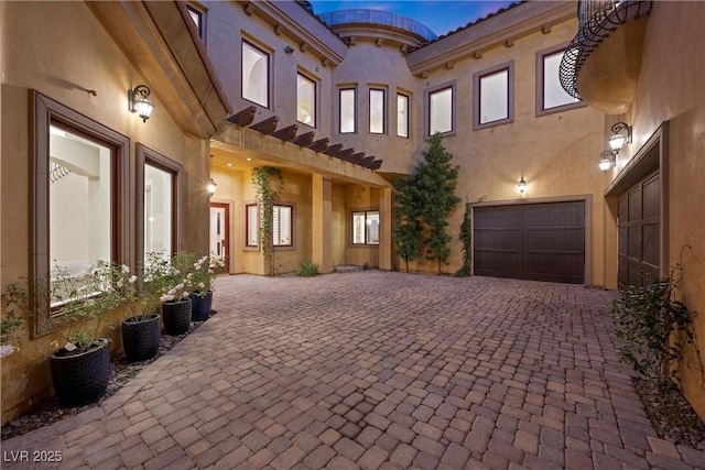 exterior space featuring decorative driveway and an attached garage