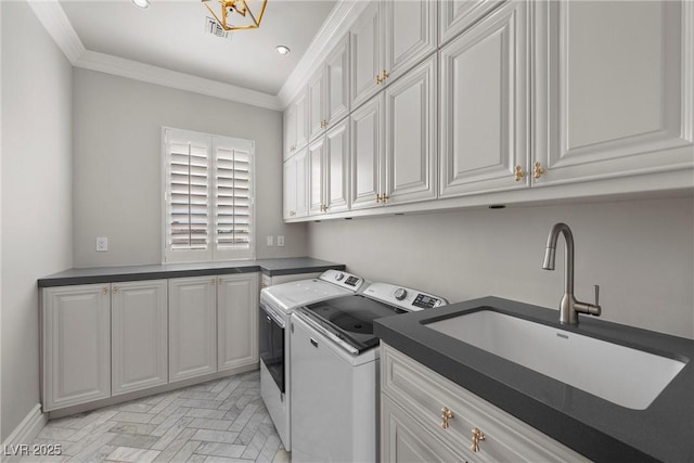 laundry room with cabinet space, visible vents, independent washer and dryer, crown molding, and a sink