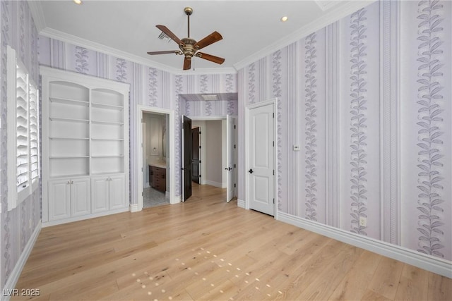 unfurnished bedroom with crown molding, light wood-style floors, baseboards, and wallpapered walls