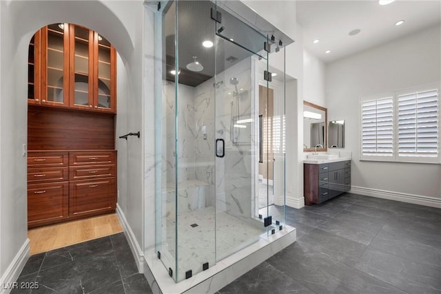 full bathroom featuring recessed lighting, a marble finish shower, vanity, and baseboards