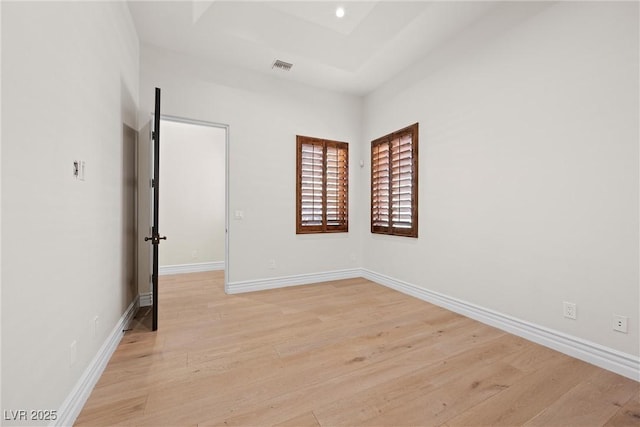 unfurnished room with light wood-type flooring, baseboards, and visible vents