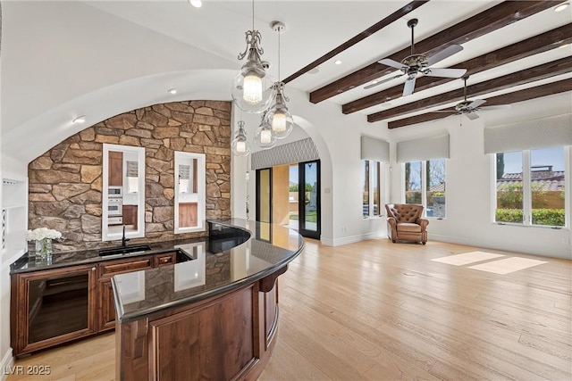 kitchen featuring open floor plan, a sink, and light wood-style floors