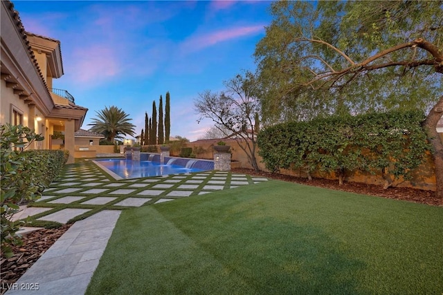 yard at dusk featuring a fenced backyard and an outdoor pool