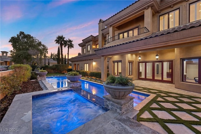 pool with a patio and an in ground hot tub